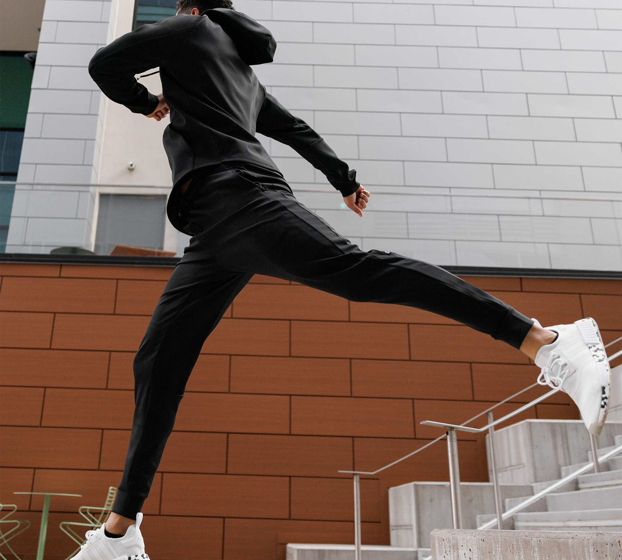 Man leaping down stairs wearing Ghostfit travel set.